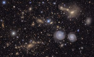 This image shows another small section of nsf doe vera c. rubin observatory's total view of the virgo cluster. visible are two prominent spiral galaxies (lower right), three merging galaxies (upper right), several groups of distant galaxies, many stars in This image shows another small section of nsf doe vera c. rubin observatory's total view of the virgo cluster. visible are two prominent spiral galaxies (lower right), three merging galaxies (upper right), several groups of distant galaxies, many stars in
